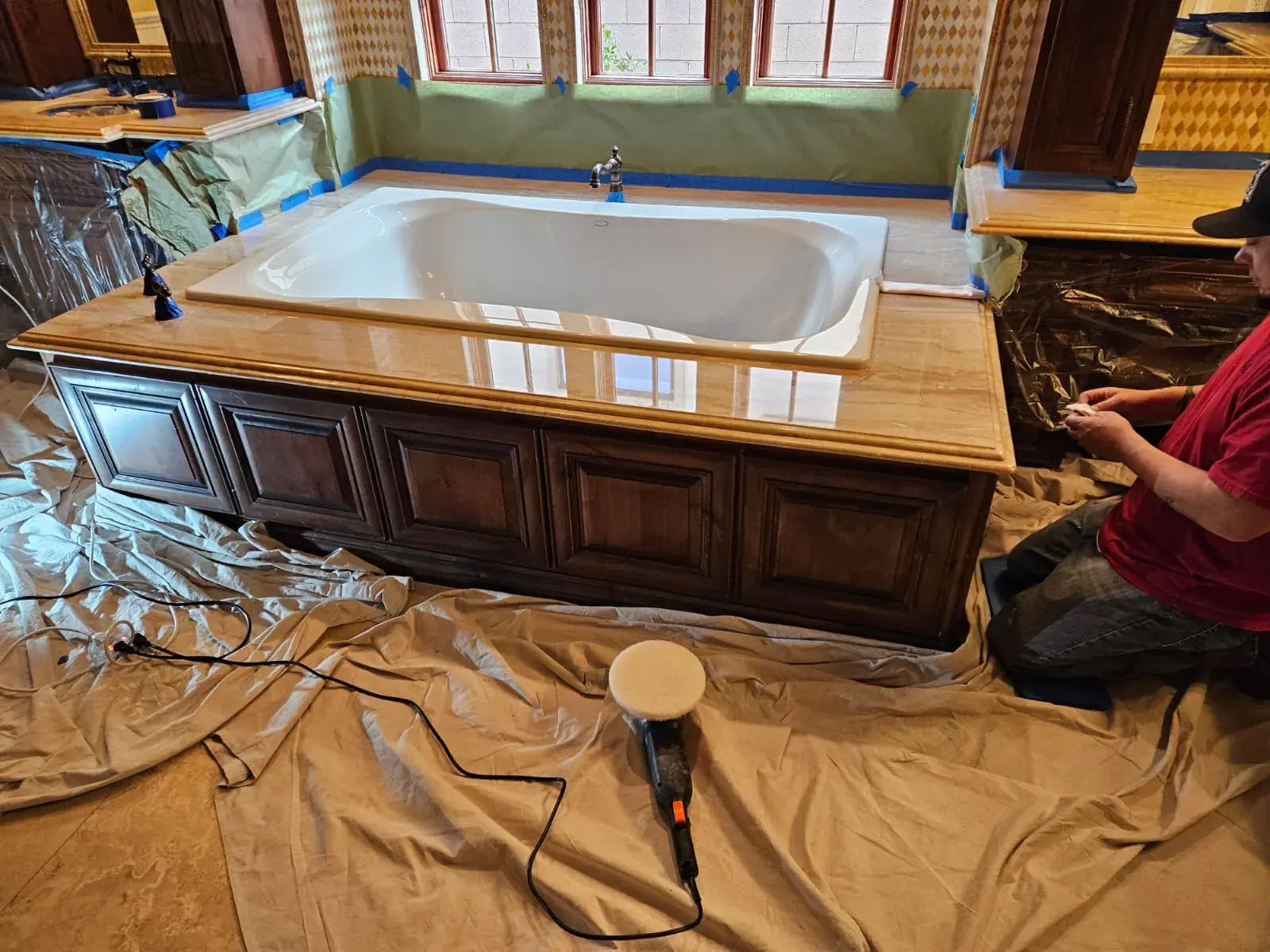 Marble tub deck being polished with the room protected