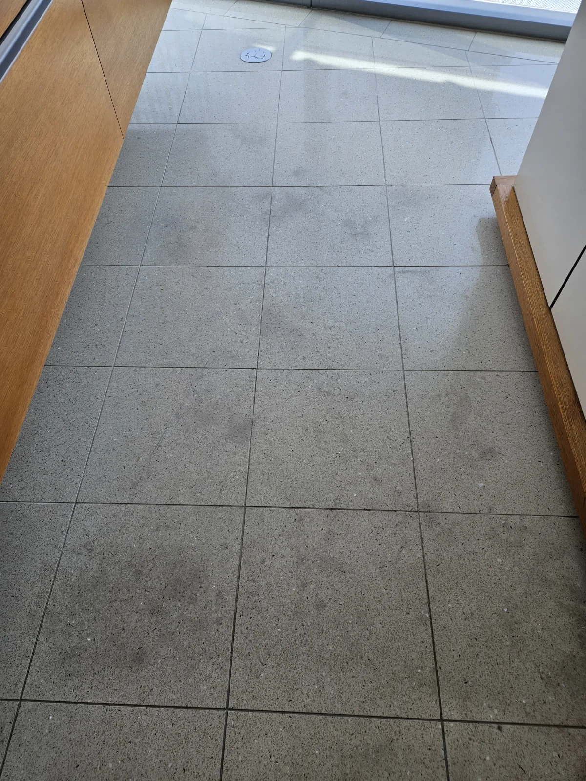 Real light tile floor with a clean, even finish beside a wall of windows
