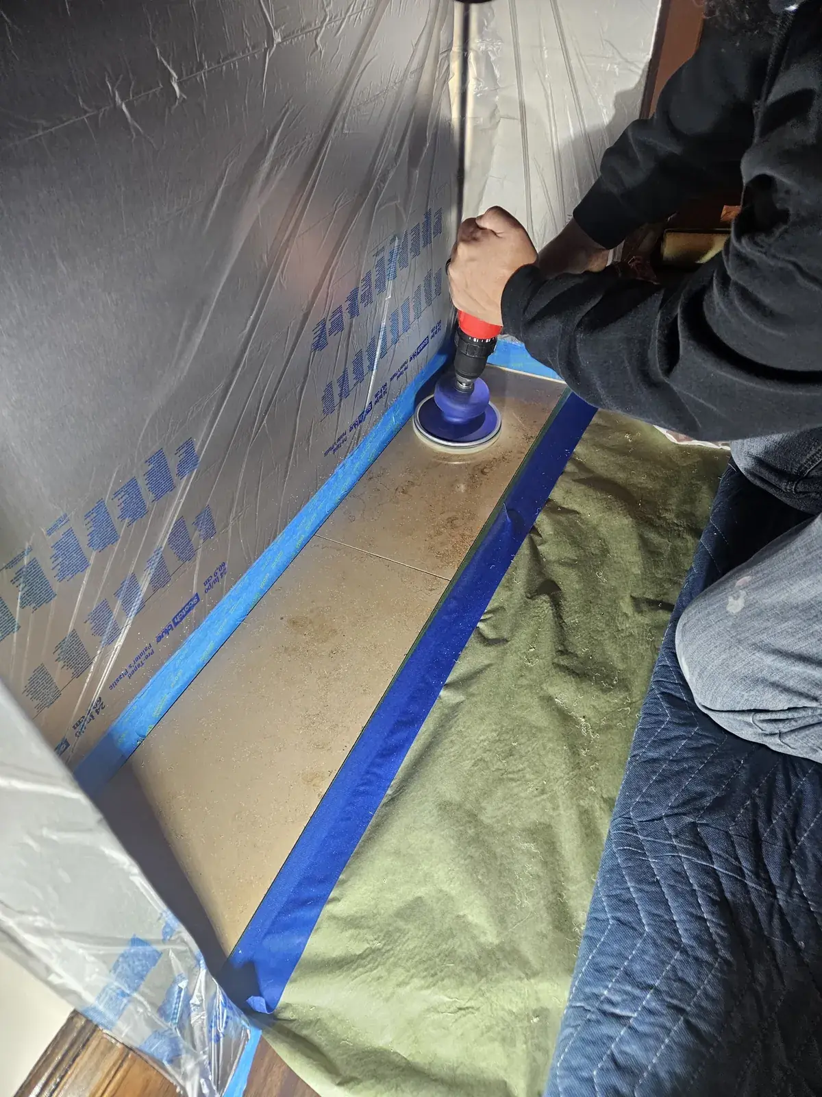 Marble threshold being polished with the surrounding surfaces carefully protected