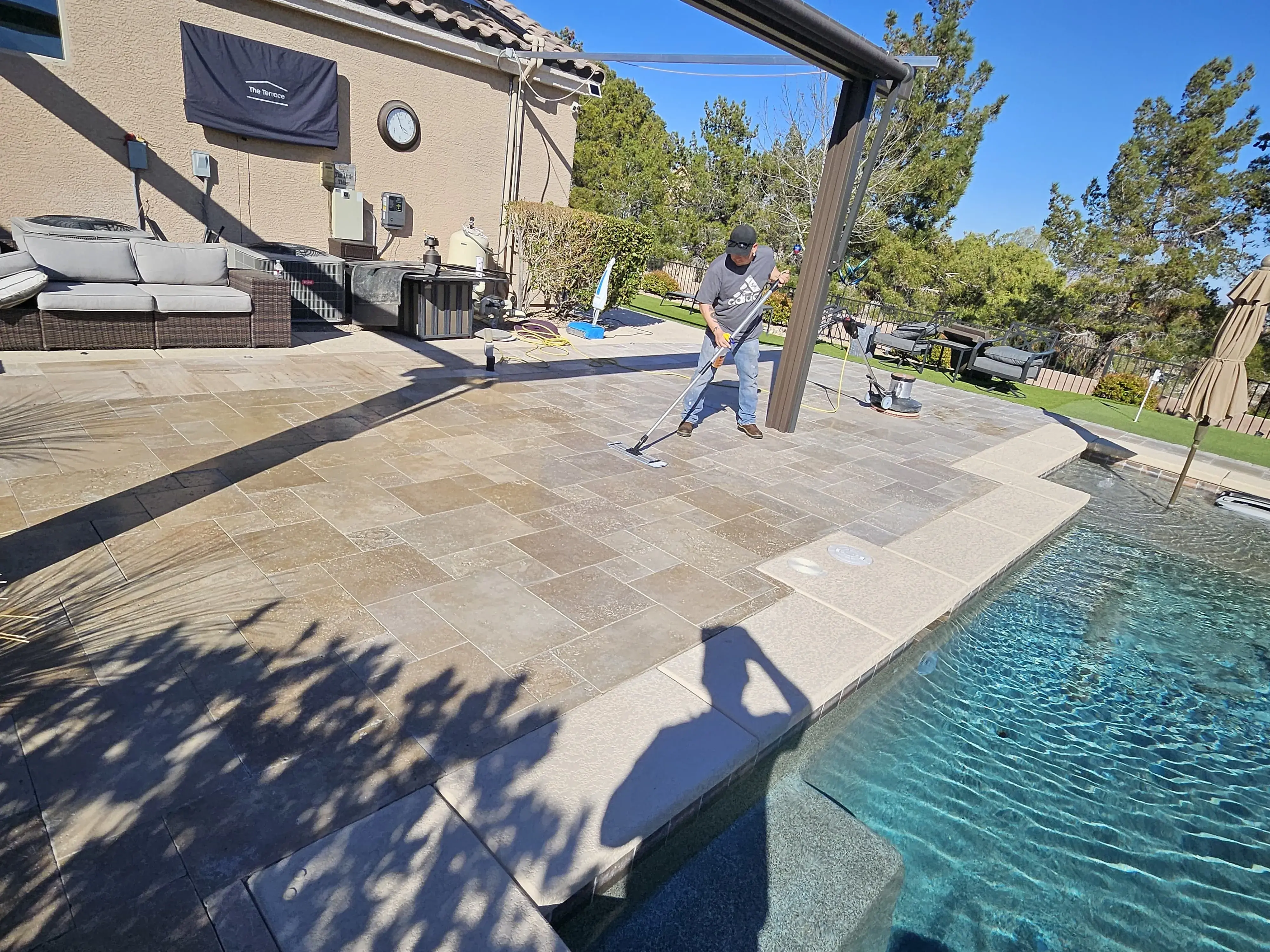 Protective sealer being applied evenly across a restored travertine pool deck